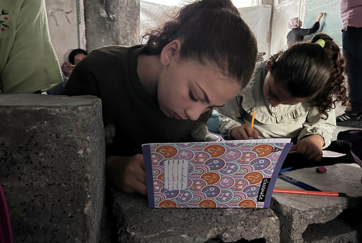 طلاب فلسطينيون يتلقون دروسهم داخل منزل مدمر شرق جباليا شمال قطاع غزة، مستخدمين الحجارة بدل المقاعد، بعد سنوات من الانقطاع عن التعليم بسبب الحرب، 17 أيار/ مايو 2026.تصوير: مطر الزاق
