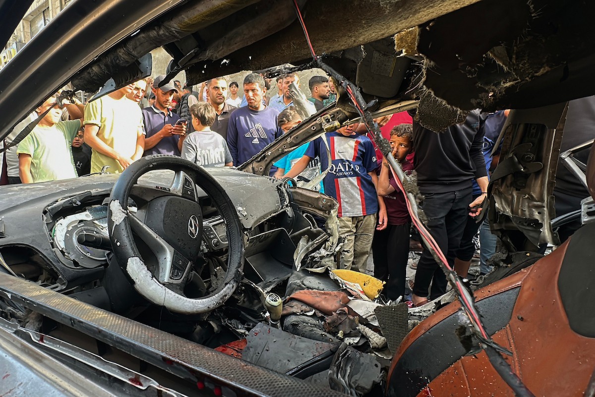 فلسطينيون يتجمعون في موقع غارة جوية إسرائيلية استهدفت مركبة في شارع الشهداء بمدينة غزة، يوم 19 مايو/أيار 2026، وأسفرت، بحسب مصادر محلية، عن استشهاد شخص وإصابة آخرين. تصوير: عمر أشتوي