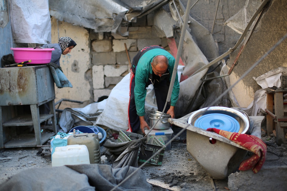 فلسطينيون يتفقدون الأضرار التي لحقت بالمنازل والشوارع عقب غارة إسرائيلية استهدفت منزلاً ومتاجر في مخيم البريج للاجئين وسط قطاع غزة، 23 مايو/أيار 2026. الصورة: معز صالحي