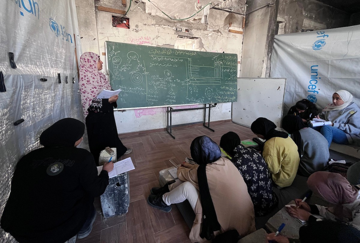 طلاب فلسطينيون يتلقون دروسهم داخل منزل مدمر شرق جباليا شمال قطاع غزة، مستخدمين الحجارة بدل المقاعد، بعد سنوات من الانقطاع عن التعليم بسبب الحرب، 17 أيار/ مايو 2026.تصوير: مطر الزاق
