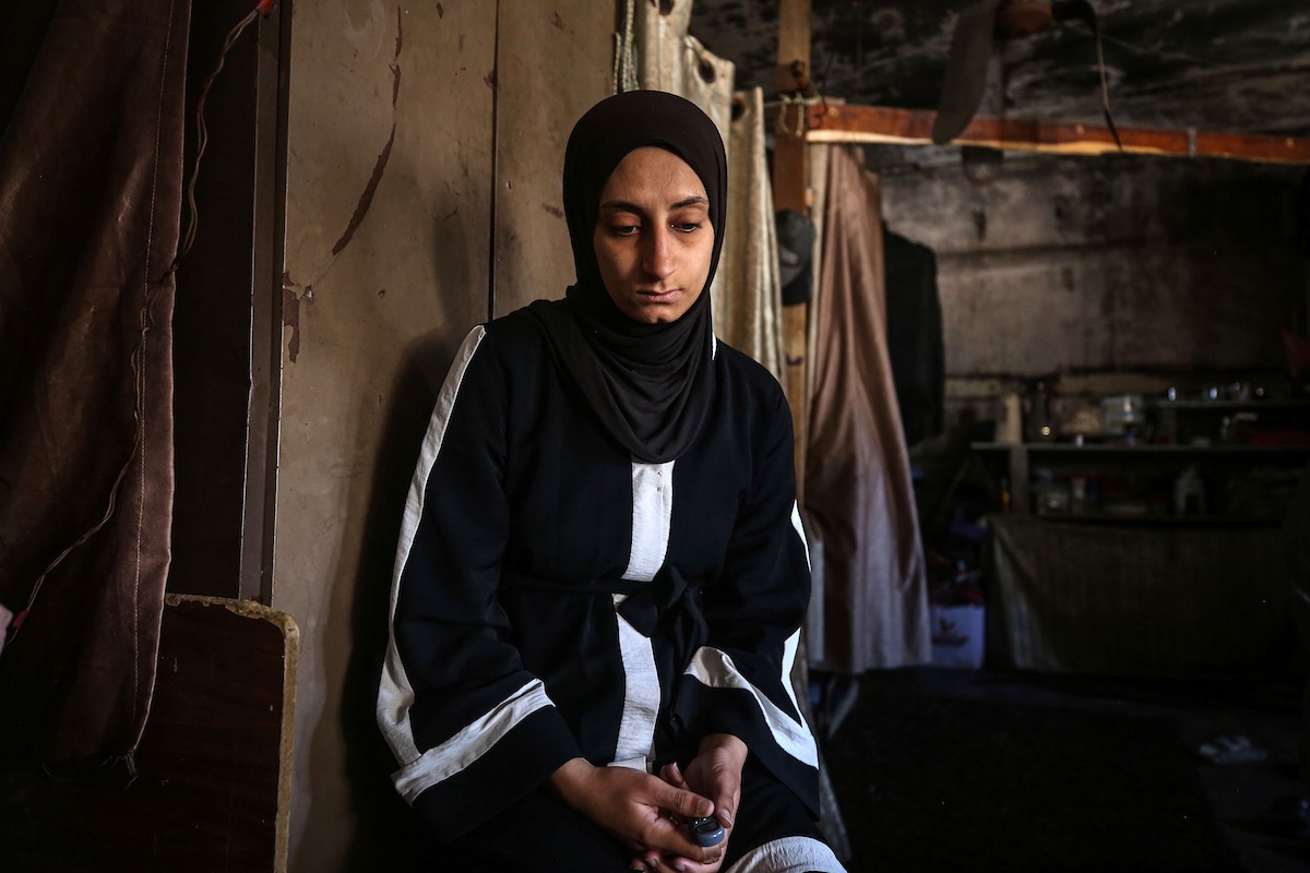 لينا مقداد، عروس فلسطينية، تنظر إلى صور ومقتنيات والدها بجانب فستان زفافها داخل مدرسة  تحُِّلت إلى مأوى للنازحين، في حي الشيخ رضوان بمدينة غزة، في 3 مايو/أيار 2026. فقدت مقداد والدها، عماد مقداد، في هجمات إسرائيلية على غزة قبل أسبوعين من زفافها