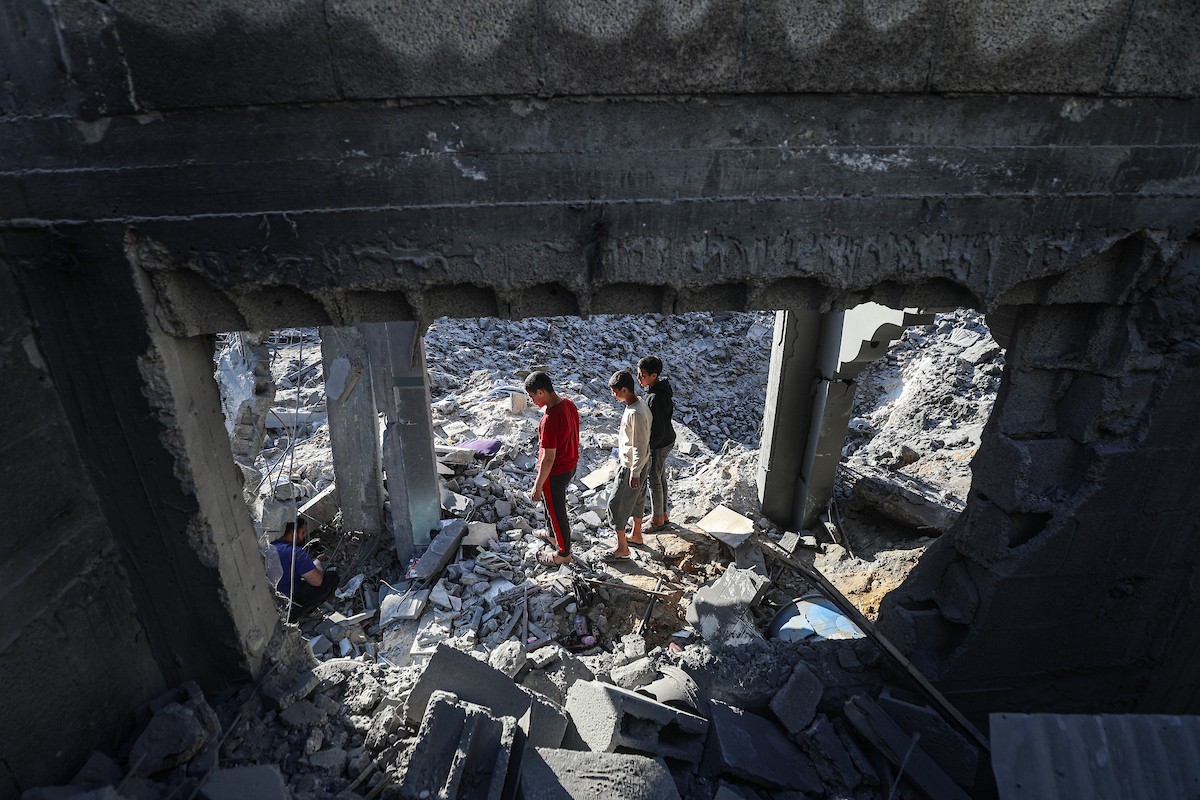 فلسطينيون يتفقدون الأضرار التي لحقت بالمنازل والشوارع عقب غارة إسرائيلية استهدفت منزلاً ومتاجر في مخيم البريج للاجئين وسط قطاع غزة، 23 مايو/أيار 2026. الصورة: معز صالحي