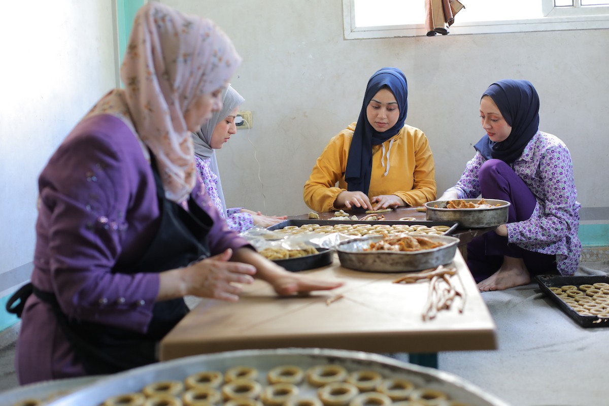 نساء فلسطينيات يُجهّزن كعكات عيد الأضحى التقليدية للبيع في مخيم النصيرات للاجئين وسط قطاع غزة، 25 مايو/أيار 2026. تصوير: حسن الجديدي