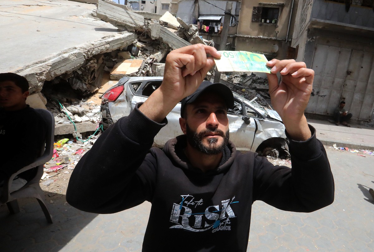 باعة فلسطينيون يعرضون بضائعهم في أكشاك على جانبي شارع الشهداء وسط مدينة غزة، في 12 مايو/أيار 2026، وسط ضعف الطلب الاستهلاكي وتدهور الأوضاع الاقتصادية الناجمة عن الحرب. تصوير: بلال أسامة