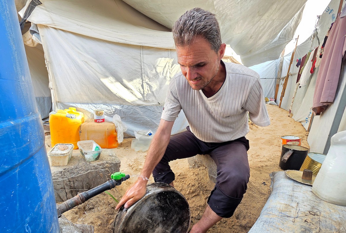 الفلسطيني محمد النواجة، الذي بُترت يده اليسرى في غارة إسرائيلية أثناء فراره من النزوح، يجلس داخل خيمة مهترئة في خان يونس جنوب قطاع غزة، في 18 مايو/أيار 2026، آملاً في الحصول على علاج خارج القطاع وطرف صناعي يساعده على مواصلة حياته. الصورة: طارق محمد