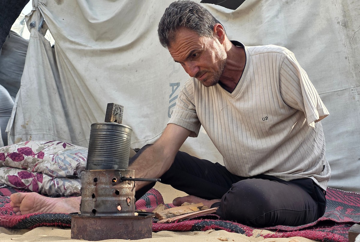 الفلسطيني محمد النواجة، الذي بُترت يده اليسرى في غارة إسرائيلية أثناء فراره من النزوح، يجلس داخل خيمة مهترئة في خان يونس جنوب قطاع غزة، في 18 مايو/أيار 2026، آملاً في الحصول على علاج خارج القطاع وطرف صناعي يساعده على مواصلة حياته. الصورة: طارق محمد