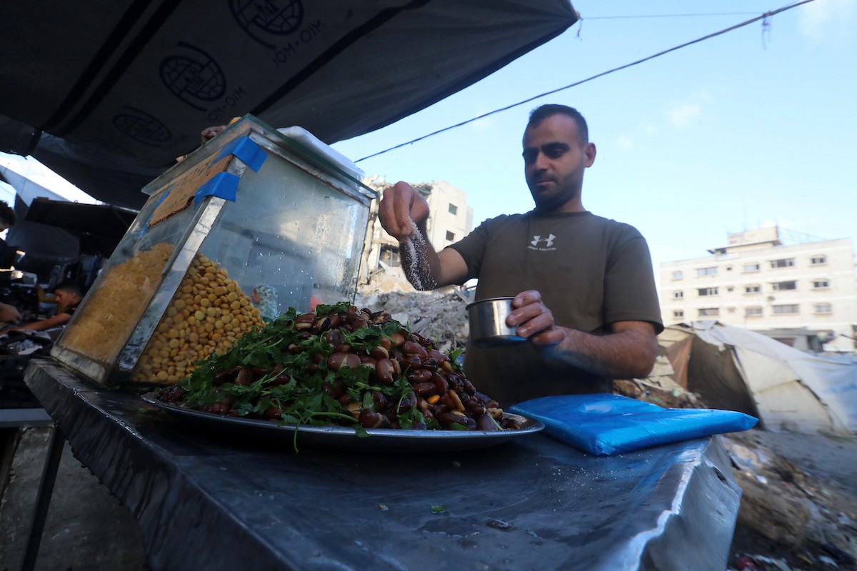 فلسطينيون يتجولون في سوق عمر المختار بمدينة غزة، حيث يعرض الباعة بضائعهم على أكشاك مؤقتة قبيل عيد الأضحى، وسط ضعف في الطلب وتراجع القدرة الشرائية، 25 مايو/أيار 2026. تصوير: بلال أسامة