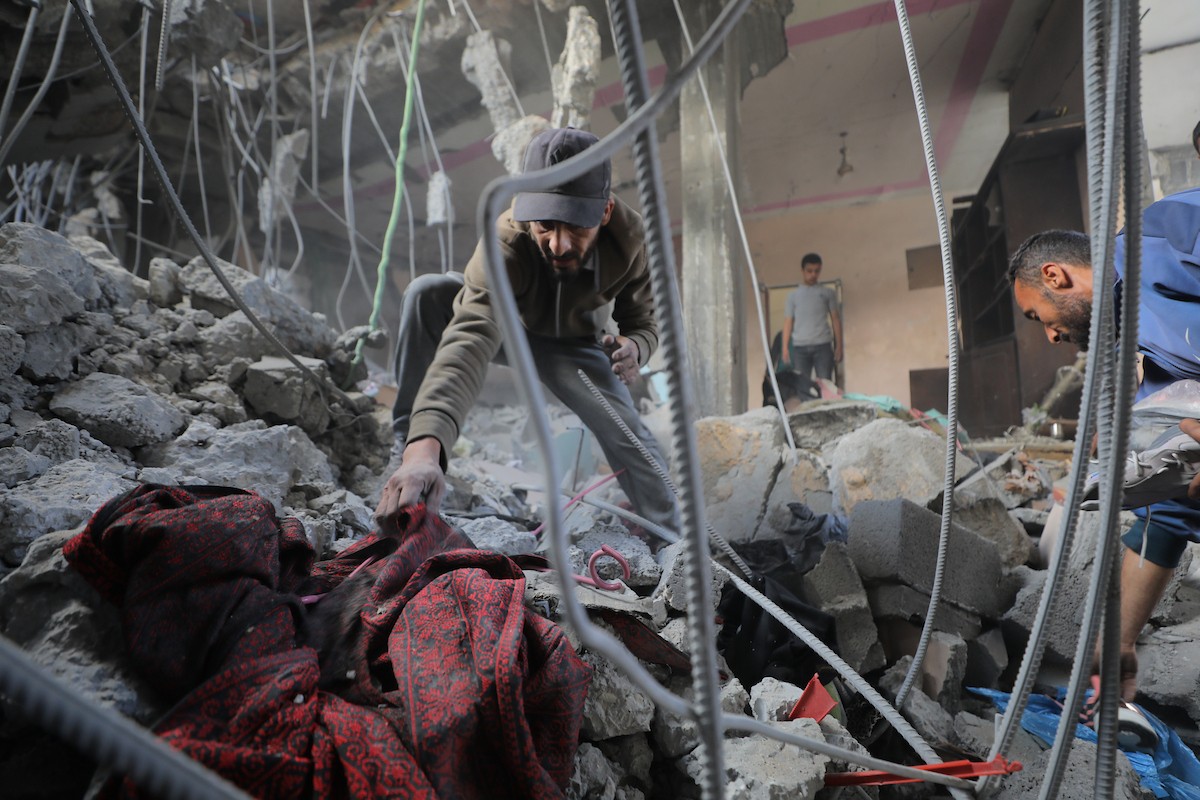 فلسطينيون يتفقدون منازلهم المدمرة عقب غارة جوية إسرائيلية ليلية على مخيم المغازي للاجئين وسط قطاع غزة، في 21 مايو/أيار 2026. الصورة: حسن الجديدي.