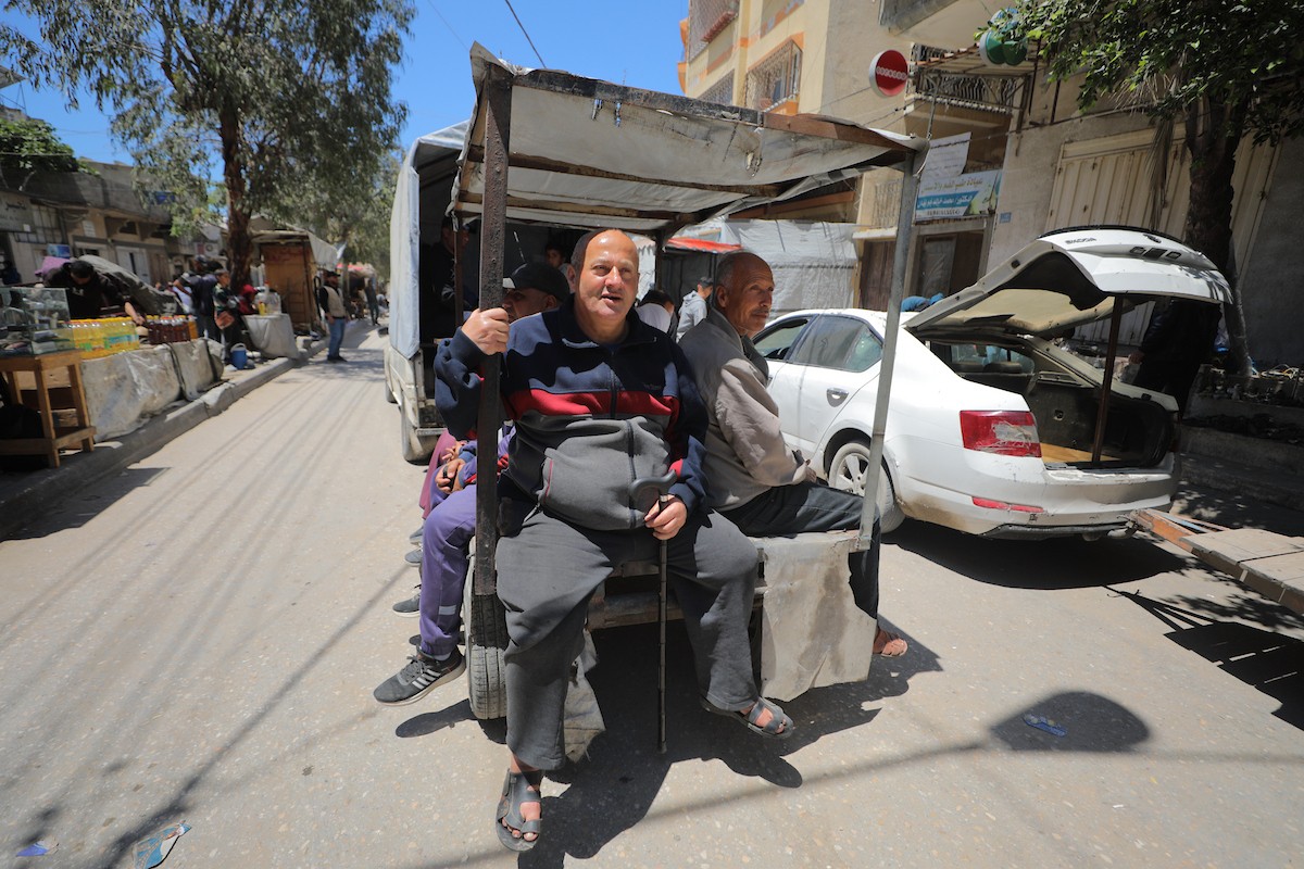 في العاشر من مايو/أيار 2026، وقف فلسطينيون على جانب أحد شوارع مخيم النصيرات للاجئين وسط قطاع غزة، بانتظار وسيلة نقل تقلّهم إلى وجهاتهم، في مشهد يومي يلخّص جانبًا من معاناة السكان تحت وطأة أزمة الوقود وارتفاع تكاليف المواصلات.(الصورة: حسن الجديدي)