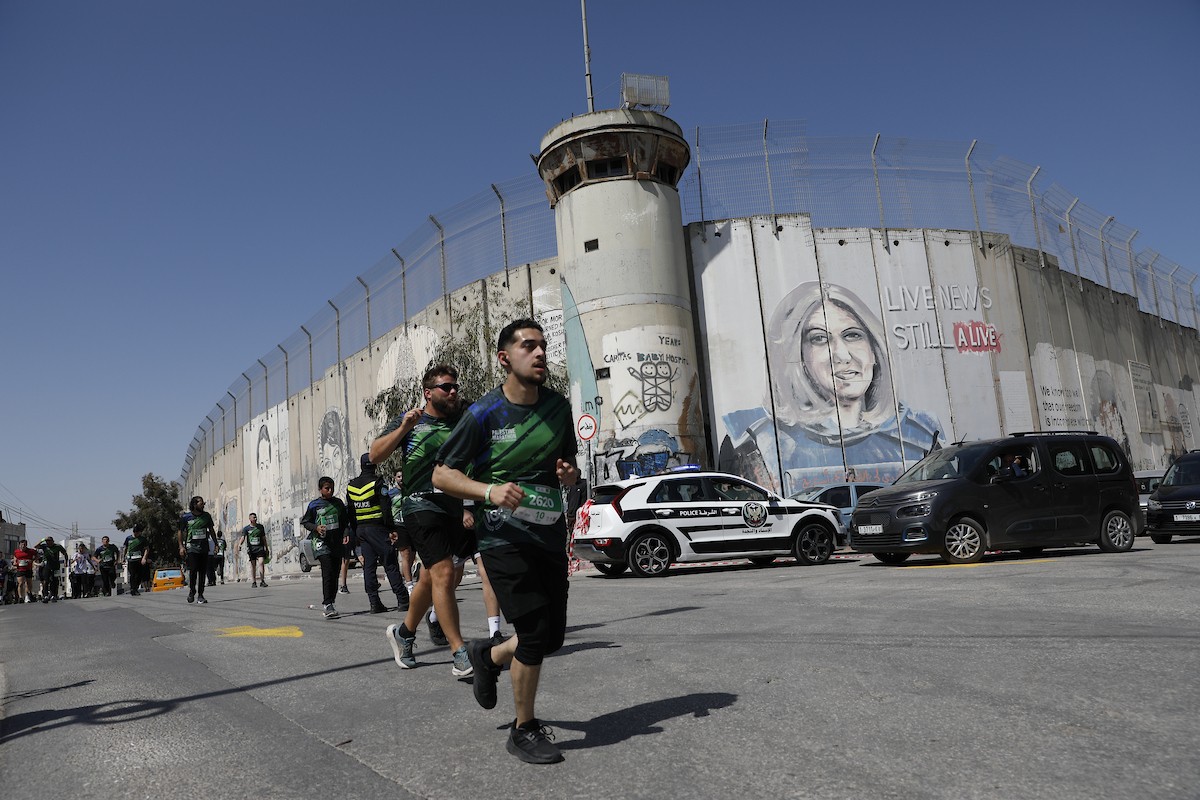 تُظهر الصورة عدائين مشاركين في ماراثون فلسطين الدولي وهم يركضون في شوارع بيت لحم، في مشهد يجمع بين الطابع الرياضي للحدث ورمزيته السياسية والإنسانية المرتبطة بحرية الحركة، 8 مايو/أيار 2026.عدسة: مأمون وزواز.