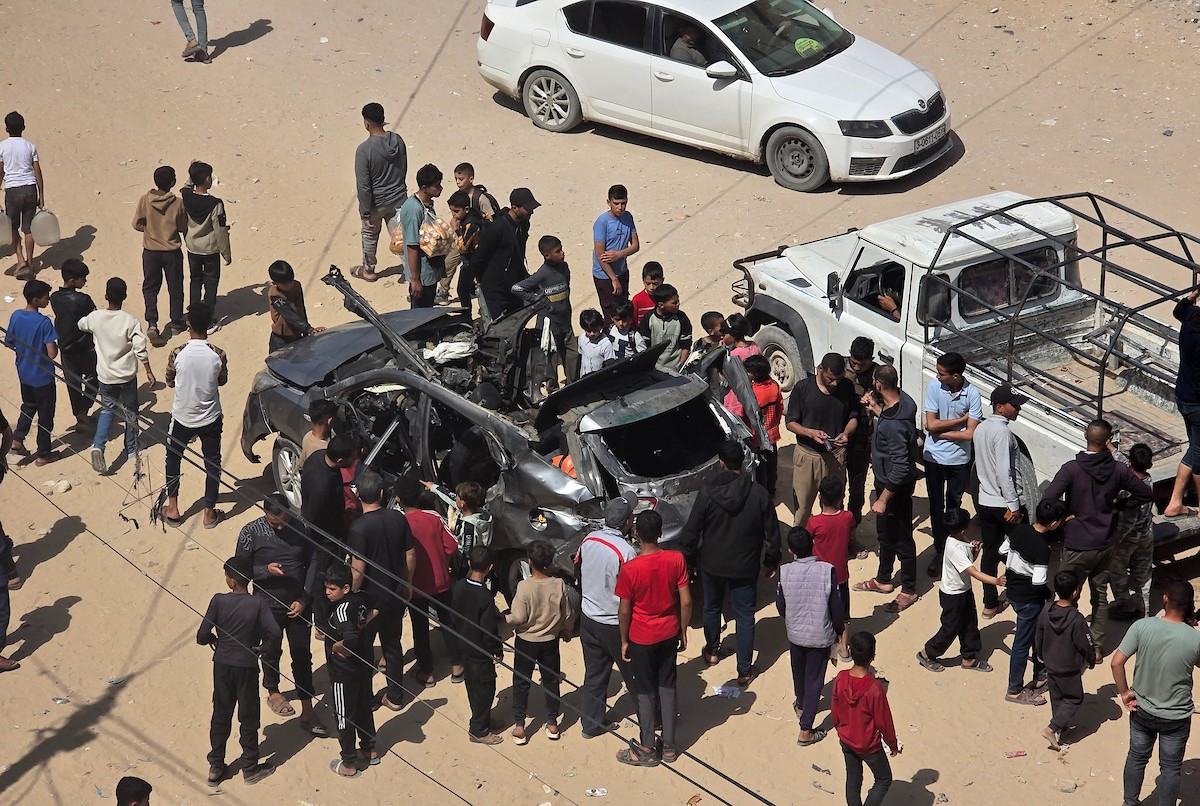تُظهر الصورة فلسطينيين يتفقدون آثار غارة إسرائيلية استهدفت مركبة في خان يونس، جنوب قطاع غزة، حيث تحولت المركبة إلى حطام، فيما واصل الأهالي التجمع في المكان وسط حالة من الصدمة والغضب، 10 أيار/ مايو 2026.(صورة: طارق محمد)