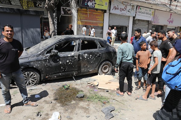 يتفقد فلسطينيون موقع غارة إسرائيلية استهدفت مركبة في حي الرمال بمدينة غزة في 22 يونيو/حزيران 2026.(صورة: بلال أسامة)