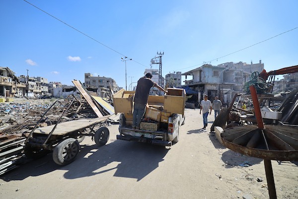 فلسطينيون يحملون أمتعتهم أثناء فرارهم من منطقة الصنافور في حي التفاح شرق مدينة غزة، عقب تقدم الآليات العسكرية الإسرائيلية. تصوير: هادي داود