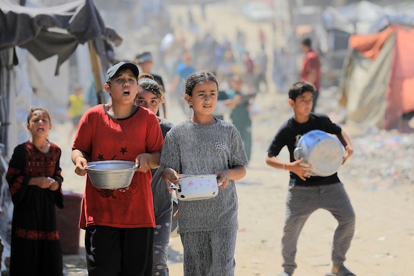 أطفال نازحون يحملون أوعية فارغة بانتظار وجبة مجانية في شرق غزة، 17 حزيران/يونيو 2026. تصوير: بلال أسامة.