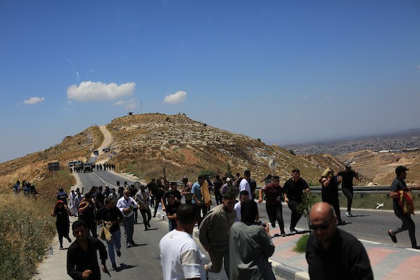 تجمّع فلسطينيون خلال احتجاجٍ على مصادرة الأراضي لتوسيع المستوطنات قرب جبل طروسة في بلدة دورا، جنوب الخليل، في 19 يونيو/حزيران 2026.صورة: مأمون وزواز