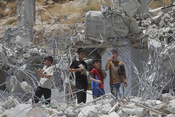 فلسطينيون يتفقدون أنقاض منزل وورشة نجارة هدمتهما جرافات الاحتلال في خربة قلقس جنوب الخليل، في 8 يونيو/حزيران 2026. تصوير: مأمون وزواز.