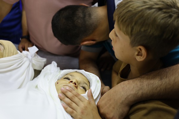 مشيعون يلتفون حول جثماني الممرض محمد الهبيل وطفله خلال جنازتهما في مستشفى الشفاء بمدينة غزة. تصوير: هادي داود