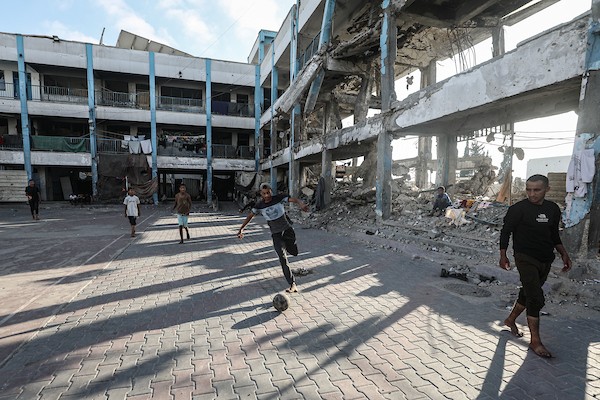أطفال فلسطينيون نازحون يلعبون كرة القدم في فناء مدرسة متضررة تابعة للأونروا بمخيم البريج وسط قطاع غزة، 13 يونيو/حزيران 2026.تصوير: معز صالح
