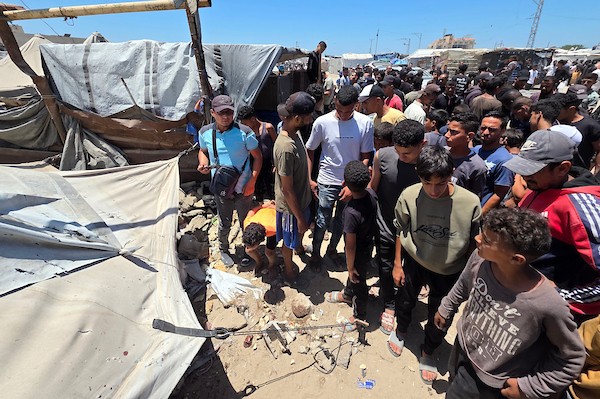 تجمّع فلسطينيون في موقع غارة إسرائيلية استهدفت دراجة نارية كهربائية قرب خيمة تأوي نازحين غرب خان يونس جنوب قطاع غزة في 2 يونيو/حزيران 2026. وبحسب مصادر طبية، أسفرت الغارة عن إصابة 10 أشخاص، بينهم اثنان في حالة حرجة. (صورة: طارق محمد)