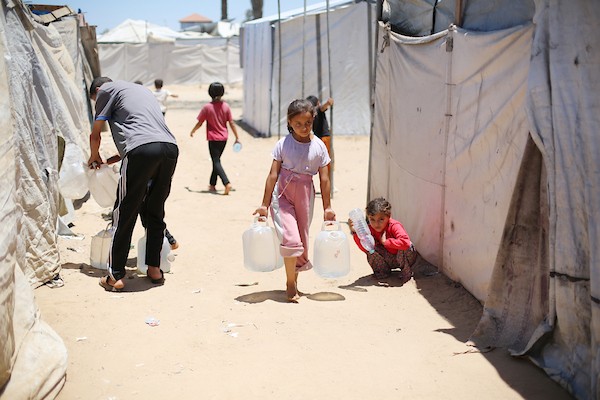 نساء وأطفال فلسطينيون يصطفون للحصول على مياه الشرب في منطقة الزويدة بوسط قطاع غزة، في 18 يونيو/حزيران 2026. تصوير: حسن الجيدي