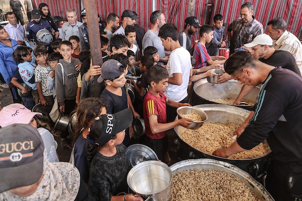 نازحون فلسطينيون يتجمعون لتلقي وجبات مجانية في مخيم النصيرات وسط قطاع غزة، حيث تتفاقم أزمة الغذاء مع تراجع عمليات الإغاثة، في 6 يونيو/حزيران 2026. صورة: معز صالحي.