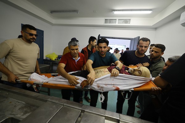 مشيعون يلتفون حول جثماني الممرض محمد الهبيل وطفله خلال جنازتهما في مستشفى الشفاء بمدينة غزة. تصوير: هادي داود