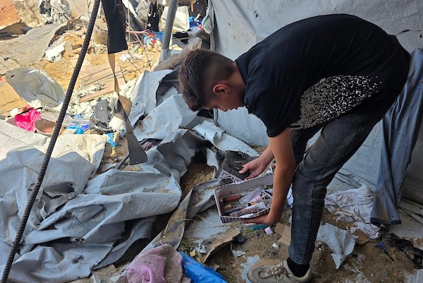نازحون فلسطينيون يتفقدون الأضرار التي لحقت بخيامهم في منطقة مواصي خان يونس، جنوب قطاع غزة، عقب غارة إسرائيلية استهدفت المنطقة. تصوير: طارق محمد