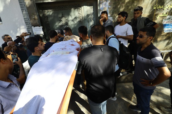 مشيعون يلتفون حول جثماني الممرض محمد الهبيل وطفله خلال جنازتهما في مستشفى الشفاء بمدينة غزة. تصوير: هادي داود