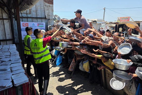 نازحون فلسطينيون ينتظرون الحصول على وجبات ساخنة من مطبخ خيري في خان يونس، جنوب قطاع غزة، وسط نقص حاد في الإمدادات الغذائية. تصوير: طارق محمد