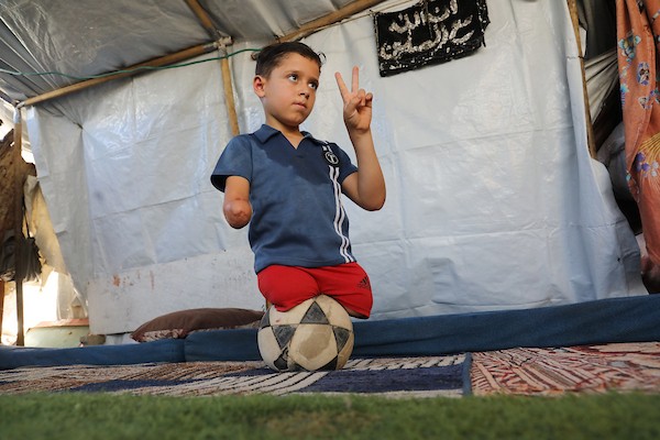 الطفل محمد شعبان (9 سنوات) رغم بتر ساقيه وذراعه يلعب كرة القدم داخل خيمة النزوح في جباليا شمال غزة، 22 يونيو/حزيران 2026.تصوير: بلال أسامة