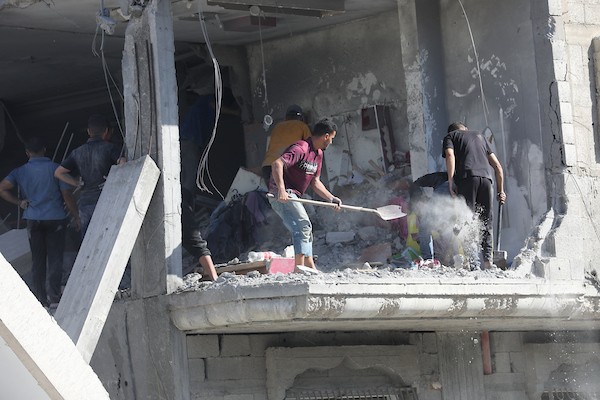 فلسطينيون يتفقدون الأضرار التي لحقت بمنازلهم عقب غارة جوية إسرائيلية استهدفت منزل عائلة درويش في مخيم النصيرات للاجئين وسط قطاع غزة. تصوير: حسن الجديدي