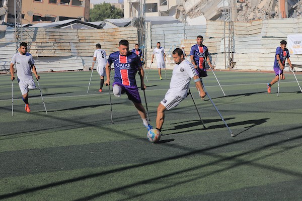 شباب فلسطينيون من مبتوري الأطراف يلعبون كرة القدم على ملعب متضرر في مدينة غزة، ضمن أنشطة لإعادة التأهيل والدعم النفسي، في 8 يونيو/حزيران 2026. تصوير: بلال أسامة.