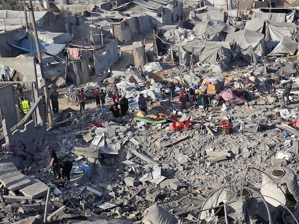 فلسطينيون يتفقدون الدمار الذي سببته غارة جوية إسرائيلية استهدفت خيام وملاجئ للنازحين في منطقة مواصي خان يونس، جنوب قطاع غزة، في 7 يونيو، 2026. تناثر الحطام والممتلكات الشخصية في جميع أنحاء المنطقة الرملية بينما كان السكان يبحثون بين حطام ملاجئهم المتضررة. (صورة:طارق محمد)