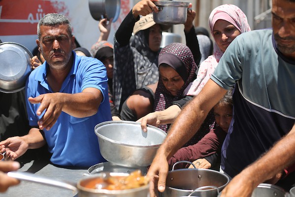 نساء وأطفال فلسطينيون نازحون ينتظرون الحصول على وجبات طعام وزعتها منظمات خيرية في مدينة غزة، في 22 يونيو/حزيران 2026.تصوير: حسن الجدي