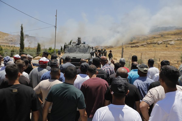 فلسطينيون يتجمعون في قرية إدنا غرب الخليل احتجاجاً على حرق أجزاء من أراضيهم، قبل أن تفرّقهم القوات الإسرائيلية بالغاز والقنابل الصوتية والرصاص الحي. تصوير: مأمون وزواز