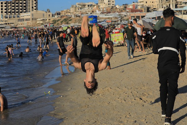 تعليق الصورة: فلسطينيون يتجمعون على شاطئ مدينة غزة في يوم حار، بحثاً عن متنفس وسط واقع إنساني وأمني صعب رغم الهدنة المعلنة. تصوير: بلال أسامة