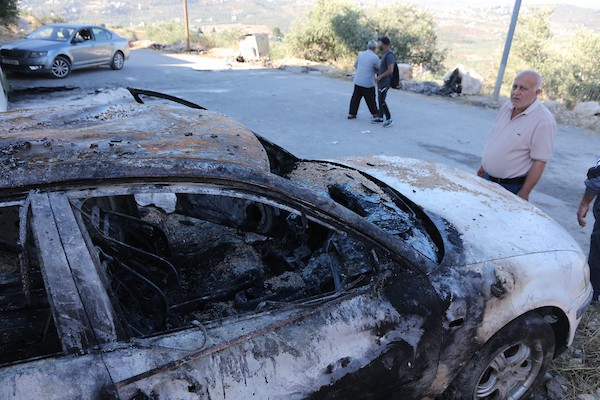 فلسطينيون يتفقدون منزلاً ومركبة محترقين عقب هجوم شنه مستوطنون في قرية بيت عمار شمال نابلس، 9 يونيو/حزيران 2026. تصوير: محمد ناصر