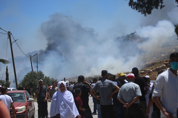 فلسطينيون يتجمعون في قرية إدنا غرب الخليل احتجاجاً على حرق أجزاء من أراضيهم، قبل أن تفرّقهم القوات الإسرائيلية بالغاز والقنابل الصوتية والرصاص الحي. تصوير: مأمون وزواز
