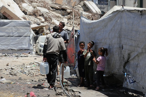 عائلات فلسطينية نازحة تملأ خزانات المياه قرب خيامها المتهالكة في مدينة غزة، وسط أزمة مياه مستمرة ونقص حاد في الخدمات الأساسية. تصوير: بلال أسامة