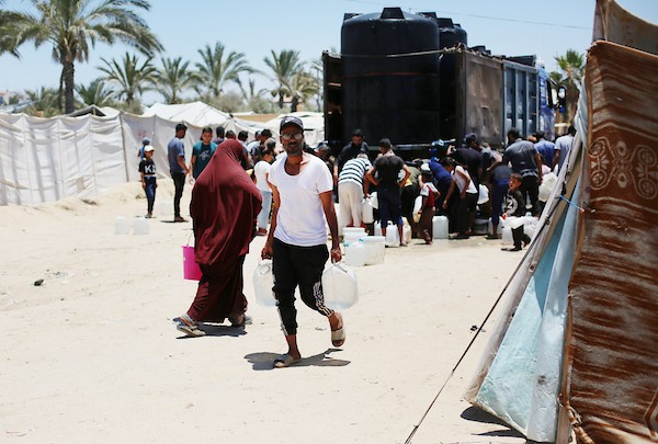 نساء وأطفال فلسطينيون يصطفون للحصول على مياه الشرب في منطقة الزويدة بوسط قطاع غزة، في 18 يونيو/حزيران 2026. تصوير: حسن الجيدي