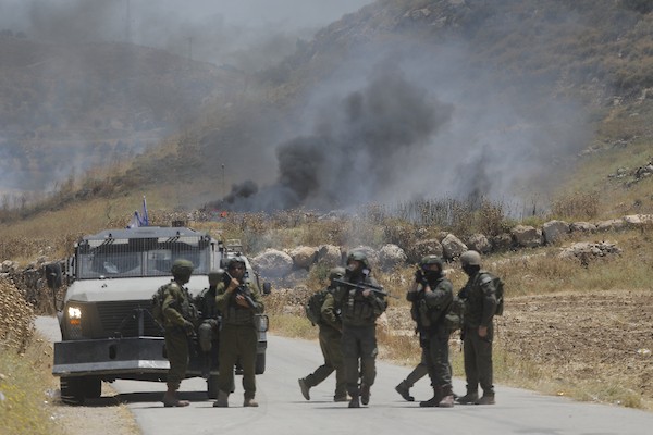 فلسطينيون يتجمعون في قرية إدنا غرب الخليل احتجاجاً على حرق أجزاء من أراضيهم، قبل أن تفرّقهم القوات الإسرائيلية بالغاز والقنابل الصوتية والرصاص الحي. تصوير: مأمون وزواز