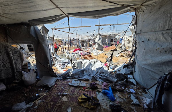 نازحون فلسطينيون يتفقدون الأضرار التي لحقت بخيامهم في منطقة مواصي خان يونس، جنوب قطاع غزة، عقب غارة إسرائيلية استهدفت المنطقة. تصوير: طارق محمد