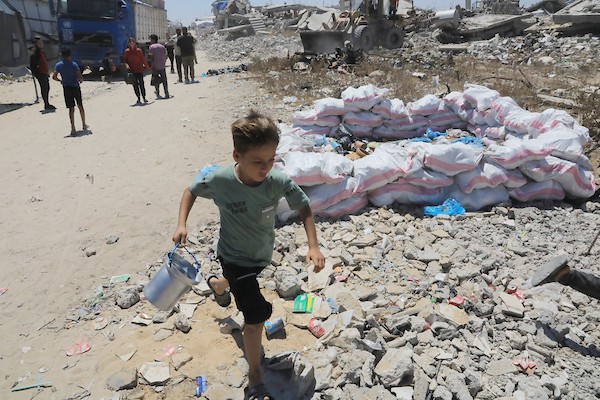 أطفال نازحون يحملون أوعية فارغة بانتظار وجبة مجانية في شرق غزة، 17 حزيران/يونيو 2026. تصوير: بلال أسامة.