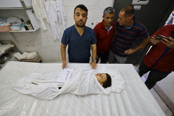 مشيعون يلتفون حول جثماني الممرض محمد الهبيل وطفله خلال جنازتهما في مستشفى الشفاء بمدينة غزة. تصوير: هادي داود