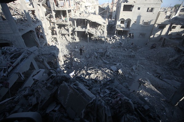 فلسطينيون يزيلون أنقاض مبنى دمرته غارة جوية إسرائيلية في مخيم المغازي للاجئين وسط قطاع غزة، الجمعة 12 يونيو/حزيران 2026. تصوير: معز صالحي