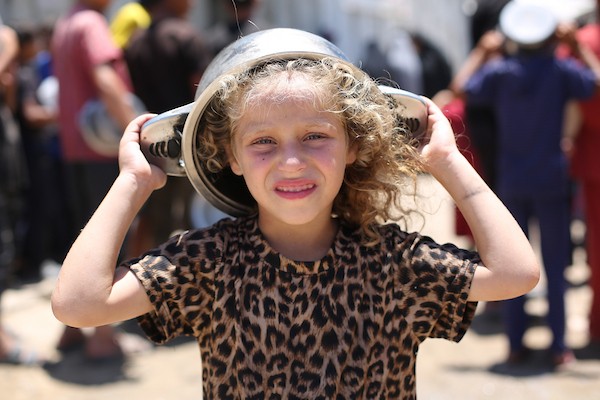 نساء وأطفال فلسطينيون نازحون ينتظرون الحصول على وجبات طعام وزعتها منظمات خيرية في مدينة غزة، في 22 يونيو/حزيران 2026.تصوير: حسن الجدي