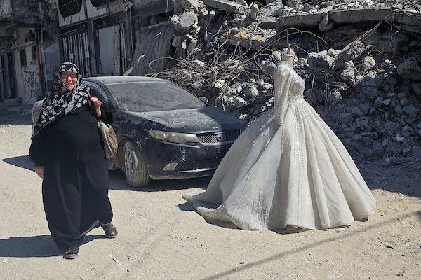 زبائن يتصفحون فساتين وبدلات زفاف داخل متجر في خان يونس، جنوبي قطاع غزة، في 1 يونيو/حزيران 2026، حيث يواصل الفلسطينيون التمسك بطقوس الزواج رغم الحرب والدمار والظروف المعيشية القاسية. تصوير: طارق محمد