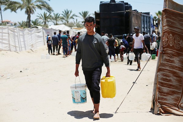 نساء وأطفال فلسطينيون يصطفون للحصول على مياه الشرب في منطقة الزويدة بوسط قطاع غزة، في 18 يونيو/حزيران 2026. تصوير: حسن الجيدي