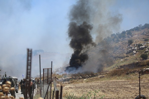 فلسطينيون يتجمعون في قرية إدنا غرب الخليل احتجاجاً على حرق أجزاء من أراضيهم، قبل أن تفرّقهم القوات الإسرائيلية بالغاز والقنابل الصوتية والرصاص الحي. تصوير: مأمون وزواز