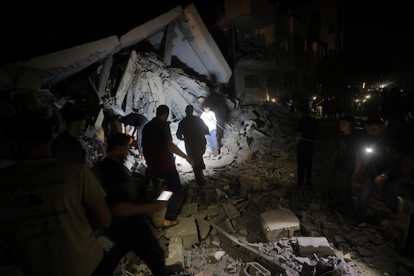 فلسطينيون يتفقدون الأضرار التي لحقت بمنازلهم عقب غارة جوية إسرائيلية استهدفت منزل عائلة درويش في مخيم النصيرات للاجئين وسط قطاع غزة. تصوير: حسن الجديدي